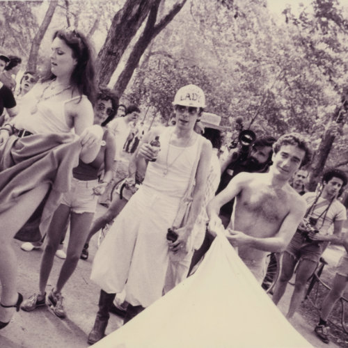 Photo de gens rassemblés au Parc La Fontaine pour la première marche de la fierté gaie à Montréal. On y aperçoit John Banks, organisateur, avec un chapeau de construction qui lit « Boss Lady. » 1979. Crédit photo : Denis Plain. Fonds Denis Plain AGQ-F0142. Collection des Archives gaies du Québec.
